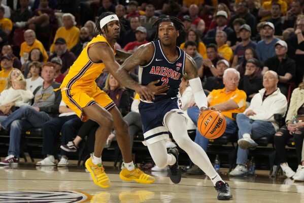 Arizona guard Caleb Love (2) drives by Arizona State guard Jamiya Neal during the first half of an NCAA college basketball game, Wednesday, Feb. 28, 2024, in Tempe, Ariz. (AP Photo/Rick Scuteri)