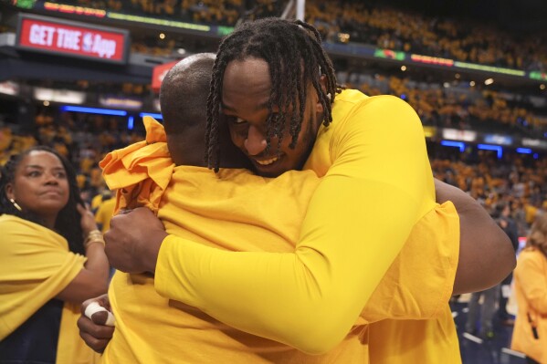 Indiana Pacers center Myles Turner, right, gets a hug after Game 6 against the Milwaukee Bucks in an NBA basketball first-round playoff series, Thursday, May 2, 2024, in Indianapolis. The Pacers won 120-98. (AP Photo/Michael Conroy)