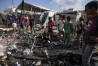 Palestinians inspect the damage at a tent area in the courtyard of Al Aqsa Martyrs hospital, hit by an Israeli bombardment on Deir al-Balah, Sunday, Aug. 4, 2024. (AP Photo/Abdel Kareem Hana)