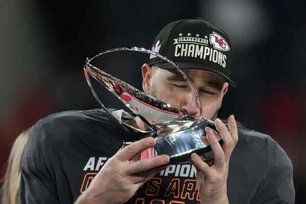 Kansas City Chiefs tight end Travis Kelce kisses the Lamar Hunt trophey after an AFC Championship NFL football game against the Baltimore Ravens, Sunday, Jan. 28, 2024, in Baltimore. The Chiefs won 17-10. (AP Photo/Nick Wass)