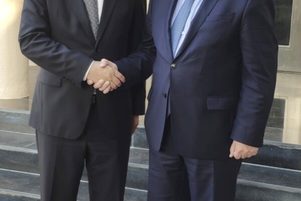 In this photo provided by the Chinese Embassy in Qatar via Xinhua News Agency, Zhai Jun, left, special envoy of the Chinese government on the Middle East issue, meets with Russia's Deputy Foreign Minister and Special Presidential Representative for the Middle East and Africa Mikhail Bogdanov in Doha, Qatar, Thursday, Oct. 19, 2023. (Chinese Embassy in Qatar/Xinhua via AP)