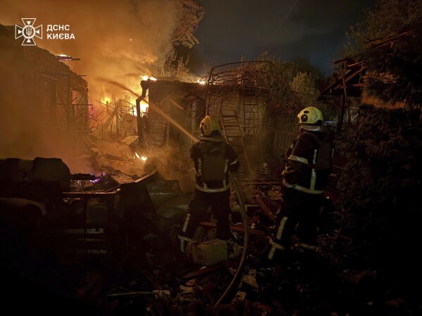 In this photo provided by the Ukrainian Emergency Service, emergency services personnel work to extinguish a fire following a Russian attack in Kyiv, Ukraine, Sunday, May 4, 2025. (Ukrainian Emergency Service via AP)