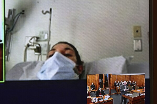 FILE - In this video screen image, Lindsay Clancy with a surgical mask over her face in a hospital appears during her arraignment on charges regarding her three children's deaths at Plymouth District Court Tuesday, Feb. 7, 2023, in Plymouth, Mass. Clancy was indicted by a Plymouth County grand jury Friday, Sept. 15, 2023, on charges of murdering her three children in what prosecutors have described a well-planned assault while her husband was out picking up medicine at a pharmacy and a takeout dinner (David Ryan/The Boston Globe via AP, Pool, File)
