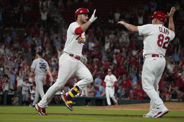 St. Louis Cardinals' Nolan Arenado is congratulated by first base coach Stubby Clapp (82) after hitting a walk-off home run off Miami Marlins relief pitcher A.J. Puk to defeat the Marlins 5-2 during the 10th inning of a baseball game Tuesday, July 18, 2023, in St. Louis. (AP Photo/Jeff Roberson)