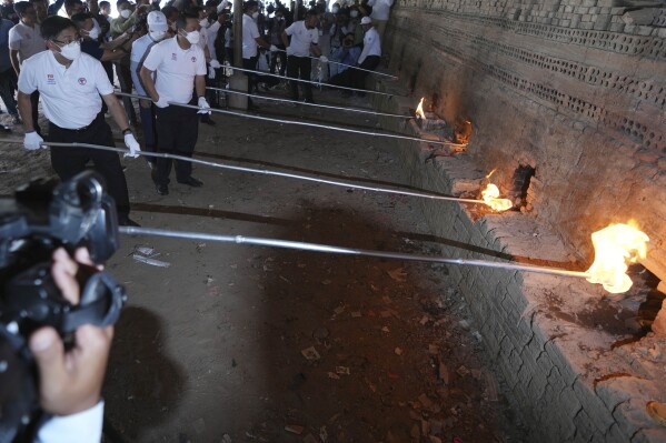 Cambodian officers burn drugs inside a brick kiln during a drug destruction ceremony to mark the International Day against Drug Abuse and Illicit Trafficking, outside Phnom Penh, Cambodia, Friday, June 14, 2024. Cambodian authorities on Friday destroyed more than 7 tons of illicit drugs and ingredients. Those drugs included heroin, marijuana, methamphetamine, ecstasy, cathinone, ketamine and nimetazepam. (AP Photo/Heng Sinith)