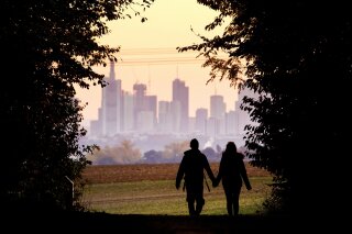 
              FILE - In this Oct. 21, 2018, file photo, a couple walks through a forest with the Frankfurt skyline in background near Frankfurt, Germany. Development that’s led to loss of habitat, climate change, overfishing, pollution and invasive species is causing a biodiversity crisis, scientists say in a new United Nations science report released Monday, May 6, 2019. (AP Photo/Michael Probst, File)
            