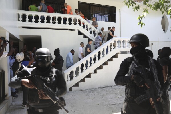 Colombians and Haitians who are accused of involvement in the 2021 assassination of Haitian President Jovenel Moise are escorted in handcuffs to their court hearing in Port-au-Prince, Haiti, Monday, May 26, 2025. (AP Photo/Odelyn Joseph)