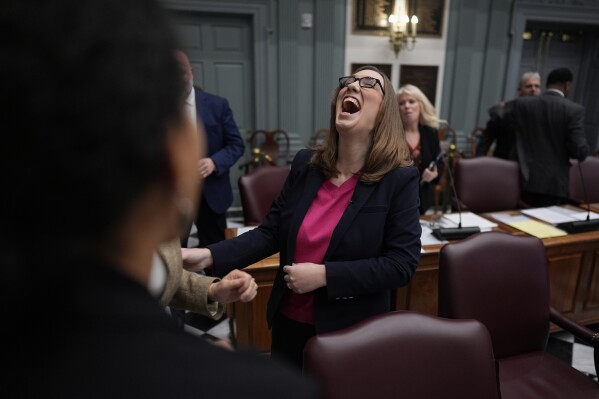 U.S.-Rep.-elect Sarah McBride, D-Del., laughs with fellow lawmakers after her farewell speech on the Senate floor during a special session, her last day as a Delaware state senator, at the Delaware Legislative Hall in Dover, Del., Monday, Dec. 16, 2024. (AP Photo/Carolyn Kaster)