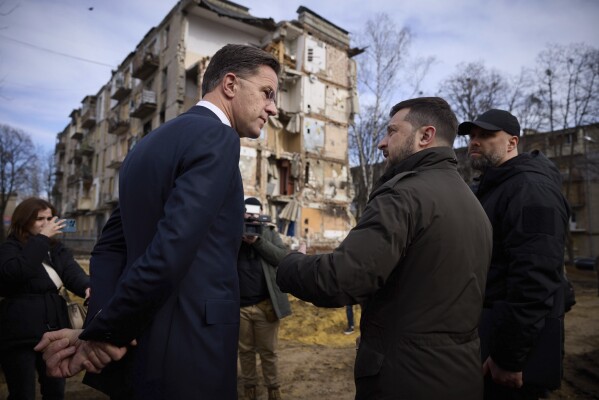 In this photo provided by the Ukrainian Presidential Press Office, Ukrainian President Volodymyr Zelenskyy, centre right, and Prime Minister of the Netherlands Mark Rutte, centre left, look at apartment houses damage in the Russian missile attacks in Kharkiv, Ukraine, Friday, March 1, 2024. (Ukrainian Presidential Press Office via AP)