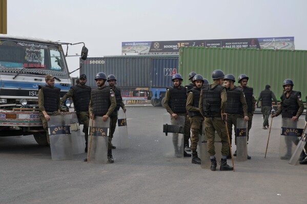 Police officers stand guard on an entry point to motorway leading to Islamabad, which has been closed by authorities due to a planned rally by supporters of imprisoned former Prime Minister Imran Khan's Pakistan Tehreek-e-Insaf party, in Lahore, Pakistan, Saturday, Nov. 23, 2024. (AP Photo/K.M. Chaudary)