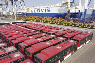 Buses for export are parked at a shipping port in Yantai in eastern China's Shandong Province, Tuesday, Feb. 1, 2022. China's exports rose by double digits in January-February in a sign global demand is reviving while imports also gained despite a weaker growth in the world's second-largest economy. (Chinatopix via AP)