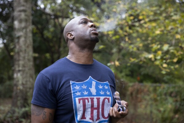 Former NFL tight end Boo Williams smokes medical marijuana at his home in Picayune, Miss., Wednesday, Nov. 15, 2023. Williams needs surgery, medicine and doctors to make the pain subside from injuries he endured during his football career. But he can't afford any of it. The 44-year-old was recently awarded $5,000 a month by the NFL's disability benefit plan. But Williams said the plan and the league have repeatedly mishandled his claims and should really have paid him $500,000 or more over the past 14 years. (AP Photo/Christiana Botic)