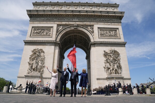 2024年6月8日，星期六，在巴黎凯旋门举行的仪式上，美国第一夫人吉尔、拜登、美国总统乔·拜登、法国总统艾曼纽尔·梅隆和布里吉特·梅隆做了手势。（美联社照片/埃文·武奇）
