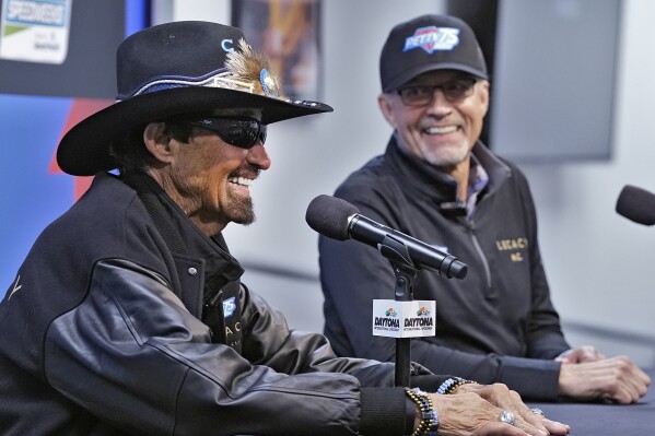 NASCAR legend Richard Petty, left, answers a question during a news conference as his son Kyle Petty looks on Wednesday, Feb. 14, 2024, at Daytona International Speedway in Daytona Beach, Fla. (AP Photo/Chris O'Meara)