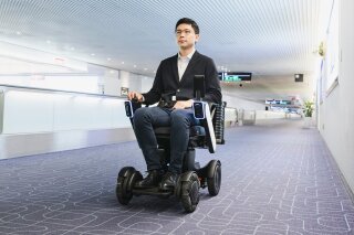 This  photo provided by WHILL, Inc., shows the trial of the company's Autonomous Drive System at Haneda Airport in Tokyo in November, 2019. The autonomous mobility system, which works like a wheelchair without anyone pushing it, is scuttling around a Tokyo airport to help with social distancing amid the coronavirus pandemic. (WHILL, Inc. via AP)