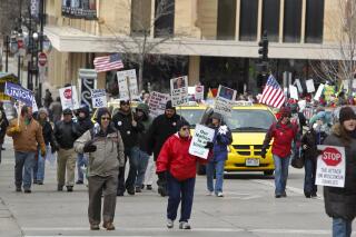 FILE - Pro-union protesters march around the the Wisconsin state Capitol in Madison, Wis., March 26, 2011. With U.S. union ranks swelling as everyone from coffee shop baristas to warehouse workers seeks to organize, Illinois voters will decide in November 2022 whether to amend their state constitution to guarantee the right to bargain collectively. (AP Photo/Andy Manis, File)