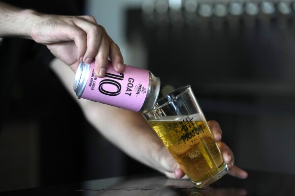 A bartender pours a beer brewed by the Prison Pals Brewery, labeled GOAT 10 in honor of Argentine soccer star Lionel Messi, at the Prison Pals Taproom, Tuesday, July 11, 2023, in Doral, Fla. Murals, burgers, beers, and billboards are just a handful of examples that show the euphoria that Messi generates in South Florida and how he will be received. (AP Photo/Lynne Sladky)