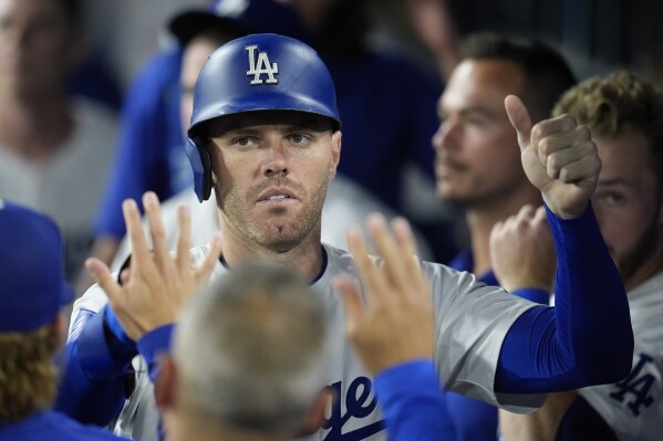 Los Angeles Dodgers' Freddie Freeman is high-fived in the dugout after scoring on a single by Teoscar Hernández during the sixth inning of a baseball game against the San Francisco Giants, Monday, July 22, 2024, in Los Angeles. (ĢӰԺ Photo/Marcio Jose Sanchez)