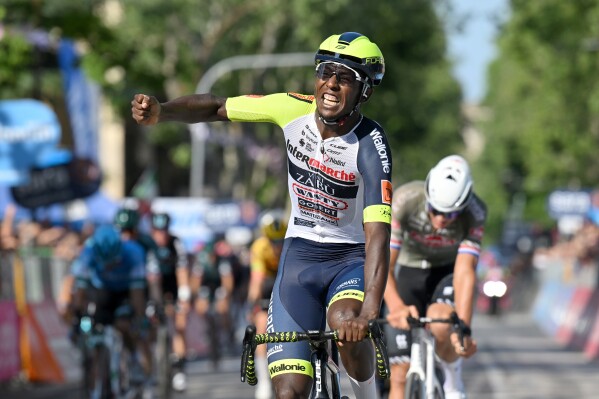 FILE - Eritrea's Biniam Girmay celebrates after winning the 10th stage of the Giro D'Italia cycling race from Pescara to Jesi, Italy, on May 17, 2022. Girmay has withdrawn from the cycling world championships in Scotland citing injury, hours after it was reported he and three teammates had been denied visas to enter the U.K. (Gian Mattia D'Alberto/LaPresse via AP, File)