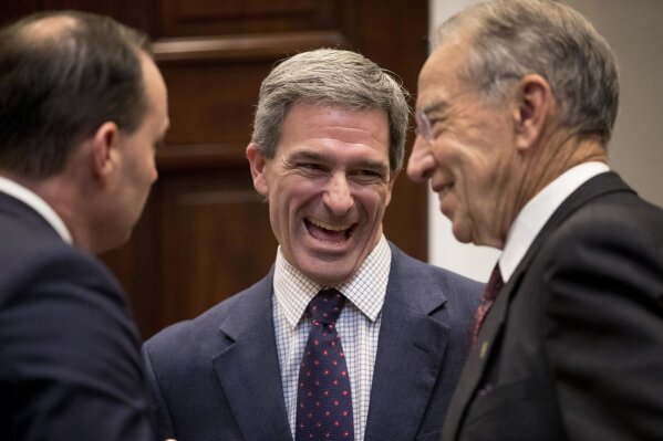 FILE - In this Nov. 14, 2018, file photo, from left, Sen. Mike Lee, R-Utah, former Virginia Attorney General Ken Cuccinelli, and Sen. Chuck Grassley, R-Iowa, laugh before President Donald Trump arrived to announce his support for the first major rewrite of the nation's criminal justice sentencing laws at White House in Washington. Cuccinelli has been named acting director of U.S. Citizenship and Immigration Services. (AP Photo/Andrew Harnik, File)