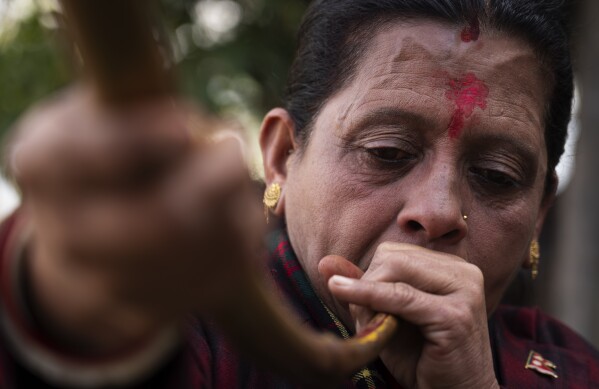 A member of Shrijanshil Mahila Sanstha, or the Self-Reliant Women’s Group, plays a traditional instrument at a wedding in Kathmandu, Nepal, Wednesday, March 6, 2024. (AP Photo/Niranjan Shrestha)
