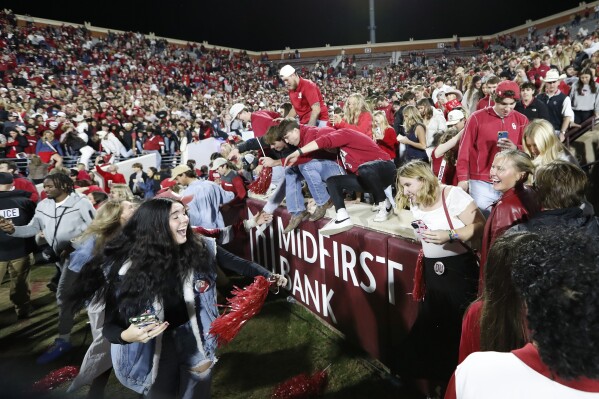 Oklahoma students and fans rush the field after Oklahoma defeated Alabama during a NCAA college football game Saturday, Nov. 23, 2024, in Norman, Okla. (AP Photo/Alonzo Adams)