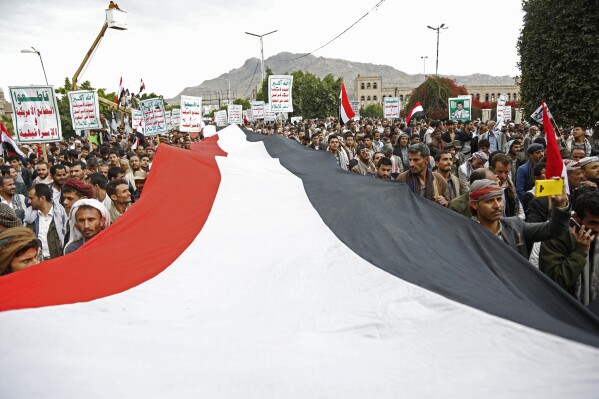 FILE - Houthi supporters chant slogans holding signs reading 