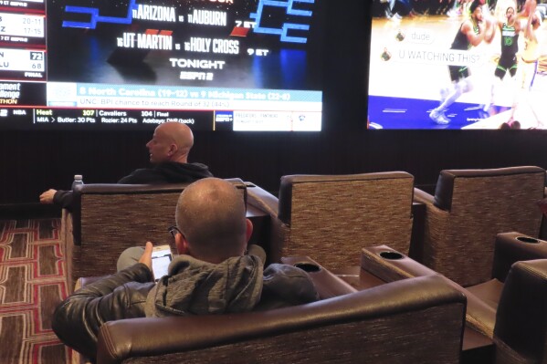 NCAA basketball tournament brackets are displayed on video screens at the Golden Nugget casino in Atlantic City N.J. on Wednesday, March 21, 2024. The American Gaming Association estimates Americans will wager $2.72 billion with legal outlets this year. (AP Photo/Wayne Parry)
