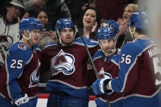 Colorado Avalanche center Alex Newhook, second from left, is congratulated after scoring a goal against the Calgary Flames by, from left, right wing Logan O'Connor, center Andrew Cogliano and defenseman Kurtis MacDermid during the first period of an NHL hockey game Saturday, Feb. 25, 2023, in Denver. (AP Photo/David Zalubowski)