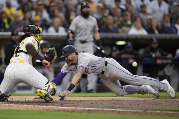 Colorado Rockies' Jake Cave, right, scores from first off a two-RBI double by Elehuris Montero as San Diego Padres catcher Luis Campusano waits for the throw during the fourth inning of a baseball game, Monday, May 13, 2024, in San Diego. (AP Photo/Gregory Bull)