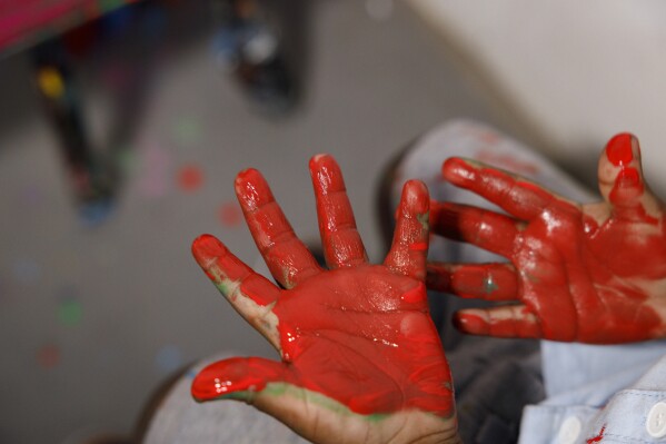 Ace Liam Nana Sam Ankrah, who turns 2 years old in July, shows off his hands of paint at his mother's art gallery in Accra, Ghana, Monday, May 27, 2024. Ankrah holds the record as the world's youngest male artist.  His mother, Chantelle Cocoa-Egan, says it all started by chance when her son, who was six months old at the time, discovered her paints.  (AP Photo/Misper Apawu)