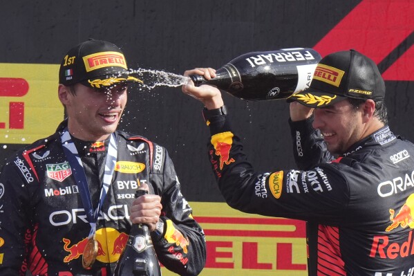 Second placed Red Bull driver Sergio Perez of Mexico, right, celebrates on the podium with winner Red Bull driver Max Verstappen of the Netherlands after the Formula One Italian Grand Prix auto race, at the Monza racetrack, in Monza, Italy, Sunday, Sept. 3, 2023. (AP Photo/Luca Bruno)
