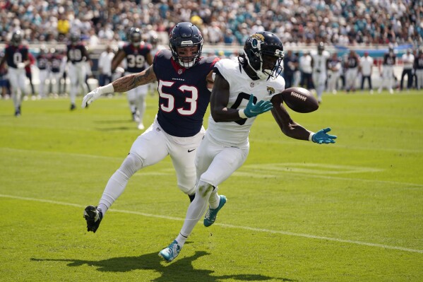 Jacksonville Jaguars wide receiver Calvin Ridley (0) bobbles a pass as Houston Texans linebacker Blake Cashman (53) defends the play during the first half of an NFL football game, Sunday, Sept. 24, 2023, in Jacksonville, Fla. (AP Photo/John Raoux)