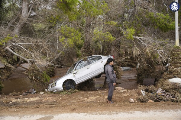 In this photo provided by the Libyan government, a car sits partly suspended in trees after being carried by floodwaters in Derna, Libya, on Monday, Sept. 11, 2023. Mediterranean storm Daniel caused devastating floods in Libya that broke dams and swept away entire neighborhoods and wrecked homes in multiple coastal towns in the east of the North African nation. As many as 2,000 people were feared dead one of the country's leaders said. (Libyan government handout via AP)