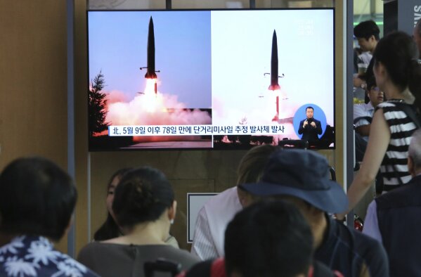 People watch a TV showing file images of North Korea's missile launch during a news program at the Seoul Railway Station in Seoul, South Korea, Thursday, July 25, 2019. North Korea fired two unidentified projectiles into the sea on Thursday, South Korea's military said, the first launches in more than two months as North Korean and U.S. officials struggle to restart nuclear diplomacy. The signs read: "North Korea fired after May 9." (AP Photo/Ahn Young-joon)