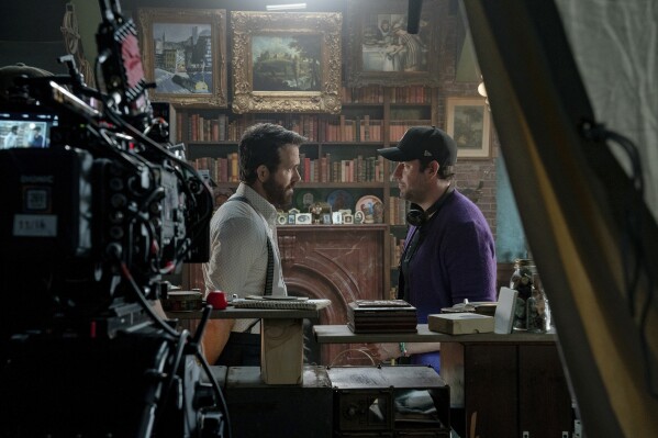 This image released by Paramount Pictures shows Ryan Reynolds, left, with director John Krasinski on the set of 