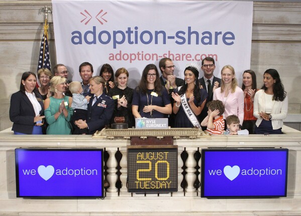 In this photo provided by the New York Stock Exchange, Adoption-Share founder and CEO Thea Ramirez, center, Miss Utah USA 2013 Marissa Powell, center right, and fellow adoption supporters ring the opening bell at the New York Stock Exchange in New York on Aug. 20, 2013. An Associated Press investigation found that Adoption-Share’s tool known as Family-Match – among the few adoption algorithms on the market in 2023 – has produced limited results in the states where it has been used, according to the organization’s self-reported data that AP obtained through public records requests from state and local agencies. (NYSE via AP)
