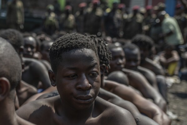 Arrested members of the Wazalendo sect are sat and lined up in Goma, Democratic Republic of the Congo, Wednesday, Aug. 30, 2023. More than 40 people died and dozens were injured in clashes in the Congolese city of Goma between protesters from the Wazalendo religious sect and the armed forces, national authorities said. (AP Photo/Moses Sawasawa)