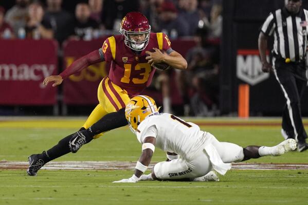 Southern California quarterback Caleb Williams, left, avoids a tackle by Arizona State defensive back Jordan Clark during the first half of an NCAA college football game Saturday, Oct. 1, 2022, in Los Angeles. (AP Photo/Mark J. Terrill)