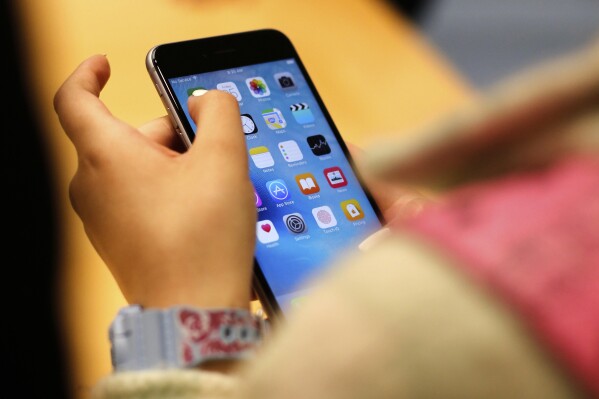 A child holds an iPhone at an Apple store on Sept. 25, 2015 in Chicago. (AP Photo/Kiichiro Sato, File)