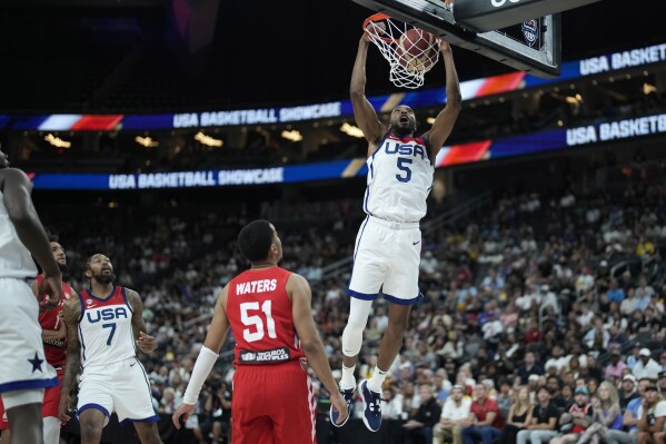 United States' Mikal Bridges (5) dunks over Puerto Rico's Tremont Waters (51) during the first half of an exhibition basketball game Monday, Aug. 7, 2023, in Las Vegas. (AP Photo/John Locher)