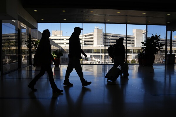 Travelers walk through Philadelphia International Airport in Philadelphia, Friday, Feb. 16, 2024. On Friday, March 15, 2024, the University of Michigan releases its preliminary reading of consumer sentiment for March. (AP Photo/Matt Rourke)
