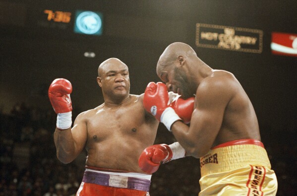 George Foreman, left, hits Michael Moorer in the face with a left during the second round of their heavyweight championship fight at the MGM Grand in Las Vegas on Saturday, Nov. 5, 1994. (AP Photo/Lennox McLendon, File)