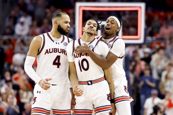 Auburn guard Chad Baker-Mazara (10) celebrates with forward Johni Broome (4) and guard Denver Jones after he made a 3-pointer against South Carolina during the first half of an NCAA college basketball game Wednesday, Feb. 14, 2024, in Auburn, Ala. (AP Photo/Butch Dill)