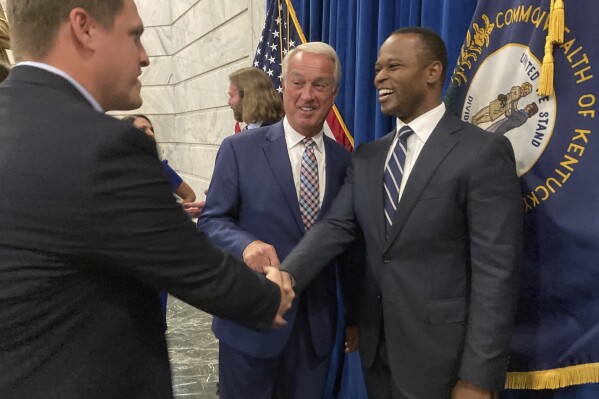 Attorney General Daniel Cameron, right, meets with people at Kentucky's Capitol in Frankfort, on Monday, Oct. 2, 2023. Cameron announced the latest round of funding for groups on the frontlines in the state's fight against drug abuse. (AP Photo/Bruce Schreiner)