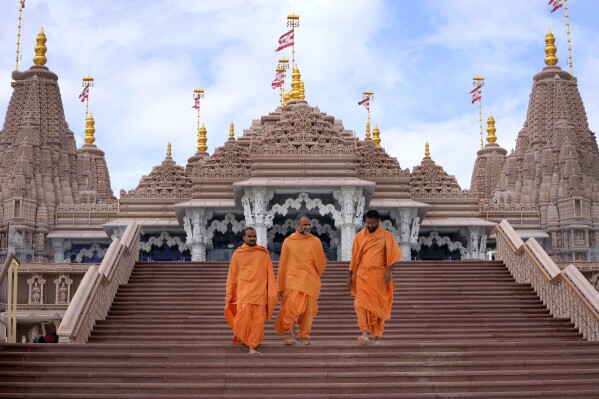 Hindu monks walk down the stairs of the first stone-built Hindu temple in Abu Mureikha, 40 kms, 25 miles, northeast of Abu Dhabi, United Arab Emirates, Monday, Feb. 12, 2024. The soon-to-open BAPS Hindu Mandir signals just how far the United Arab Emirates has come in acknowledging the different faiths of its expatriate community, long dominated by Indians who power life across its construction sites and boardrooms. (AP Photo/Kamran Jebreili)