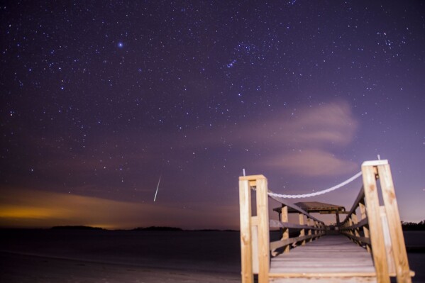 FILE - The Geminid meteor shower lights up the night sky above Tybee Island, Ga., early Thursday, Dec. 14, 2017. The year’s best meteor shower, the Geminids, peaks this week, with lucky stargazers seeing as many as one or even two a minute in the darkest spots. The meteors will reach their frenzy Thursday, Dec. 14, 2023. (Will Peebles/Savannah Morning News via AP, File)