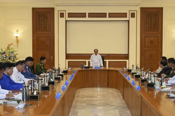 In this photo released from the The Military True News Information Team on Nov.8, 2023, Myint Swe, center, acting President of the military government, speaks during a meeting with members the National Defense and Security Council including Senior Gen. Min Aung Hlaing, center left, chairman of State Administration Council, and Vice President Henry Van Thio, center right, in Naypyitaw, Myanmar. (The Military True News Information Team via AP)
