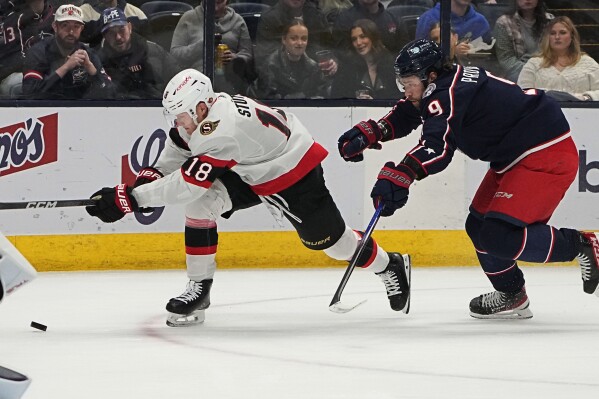 Ottawa Senators center Tim Stutzle (18) is defended by Columbus Blue Jackets defenseman Ivan Provorov (9) during the first period of an NHL hockey game Friday, Dec. 1, 2023, in Columbus, Ohio. (AP Photo/Sue Ogrocki)