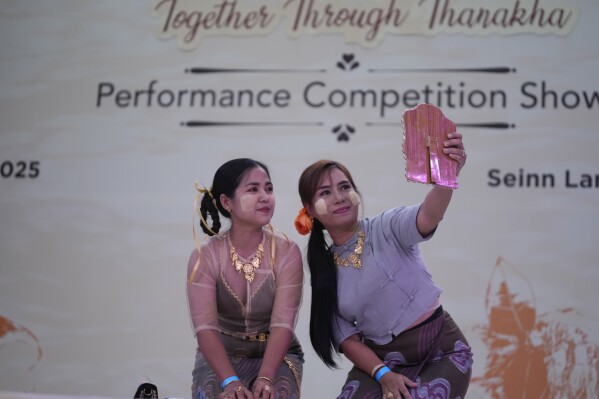 Artists with traditional attire put Thanakha, traditional make-up, on their faces as they take part in performance competition show aiming to submit the traditional culture of Thanakha to UNESCO's Intangible Cultural Heritage of Humanity, Wednesday, Feb.12, 2025 in Yangon, Myanmar. (AP Photo/Thein Zaw)
